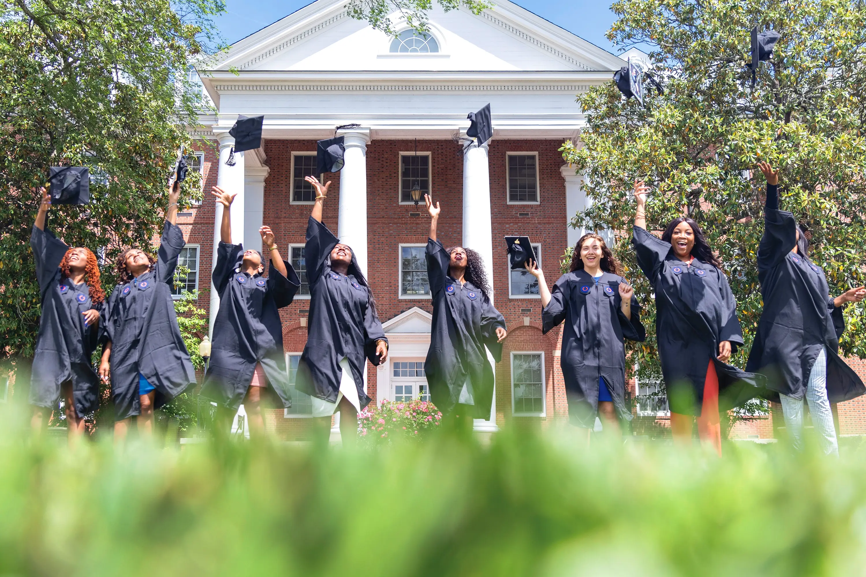 Virginia State University students tossing their caps