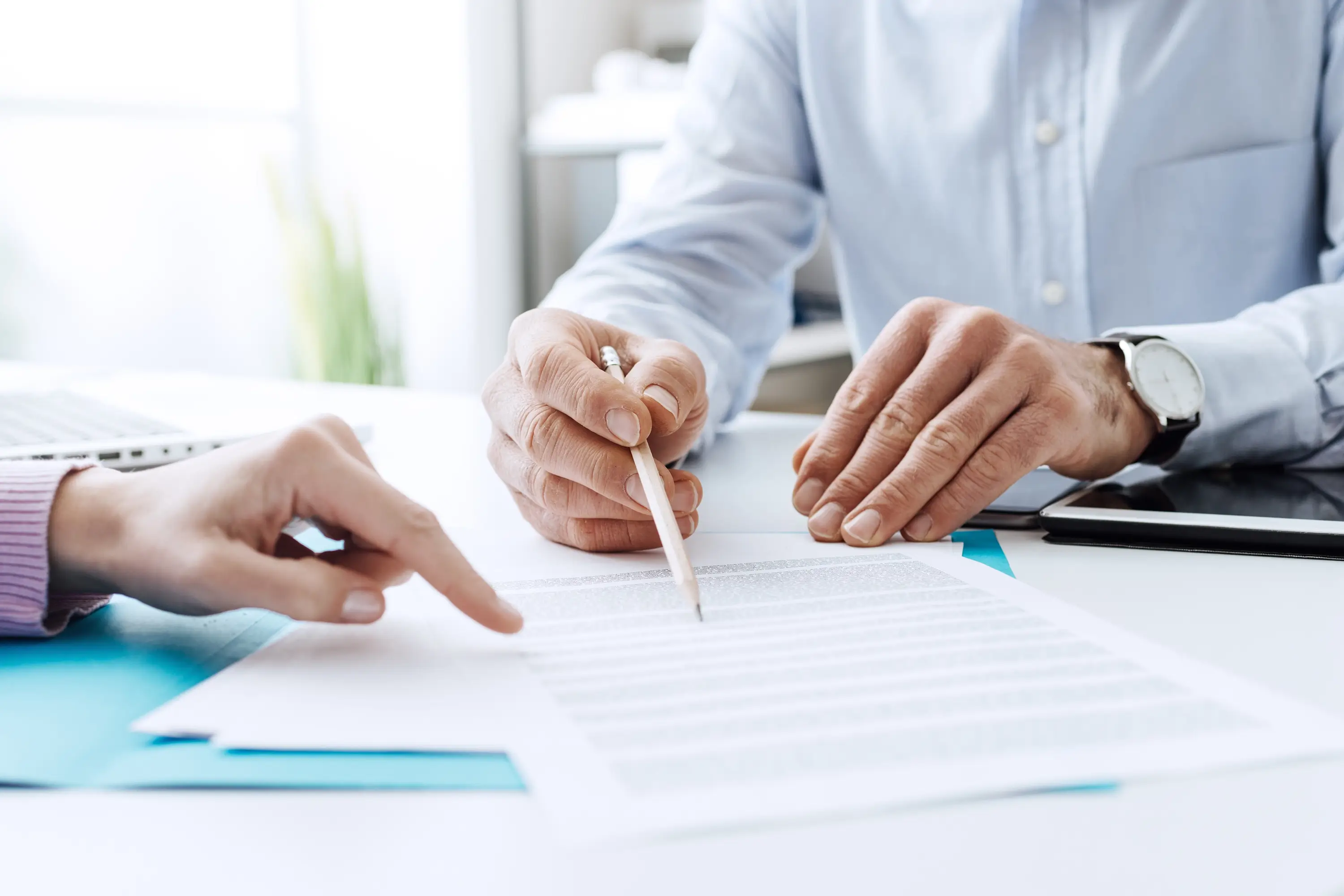 A stock photo of two business people going through contract details