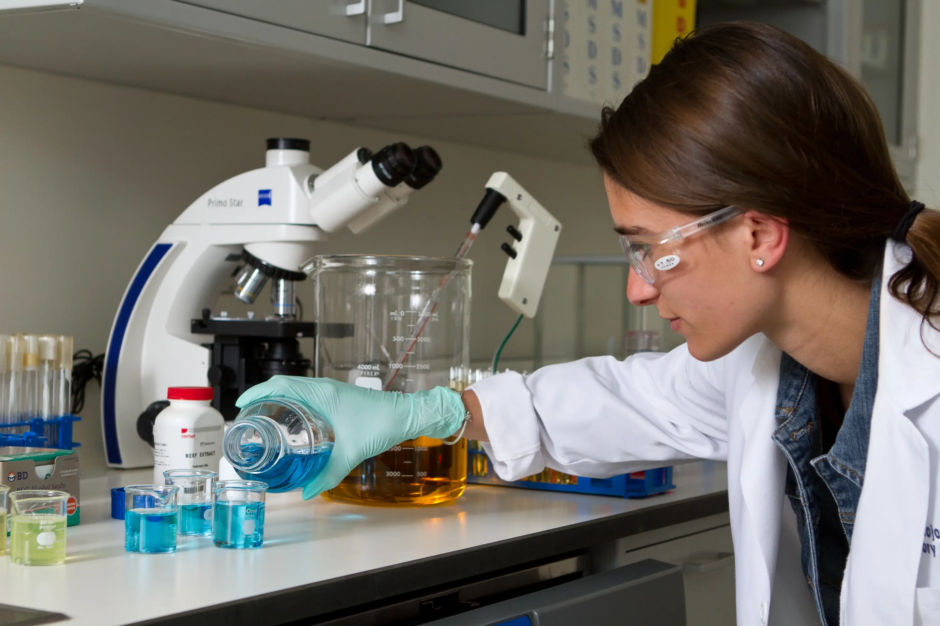 A Reynolds Community College science student pouring liquids