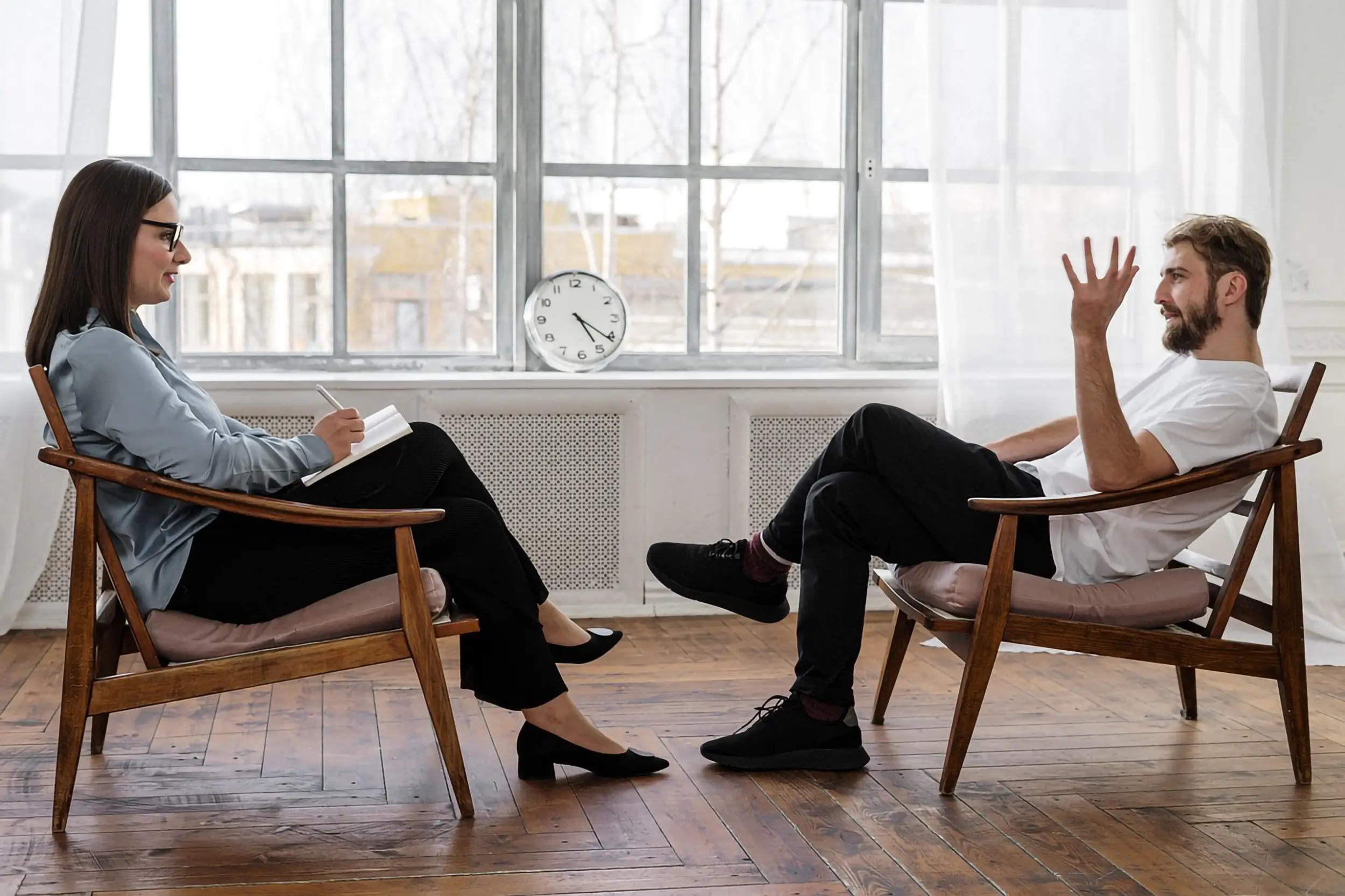 A stock photo of a woman therapist talking to a man