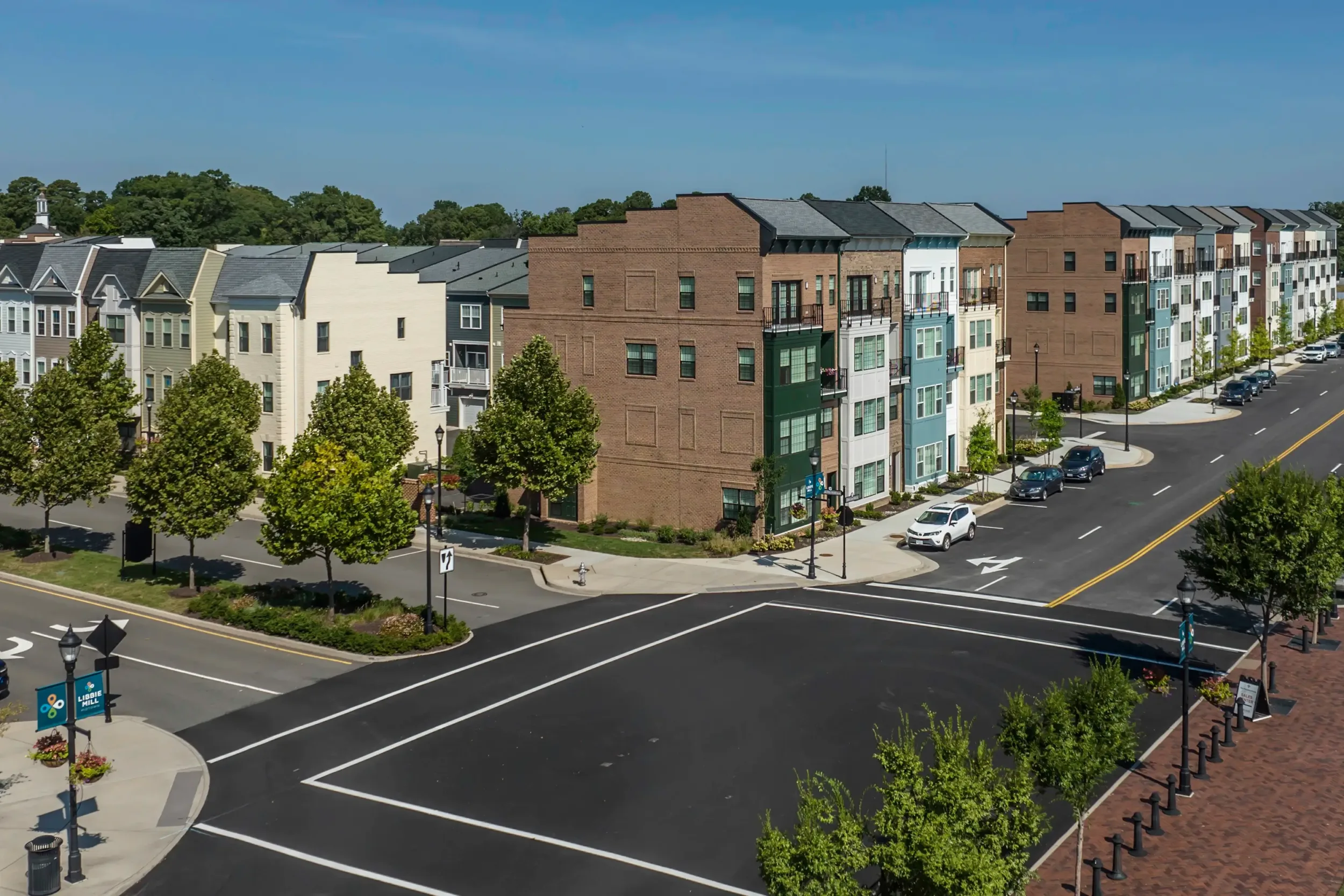 A drone shot of an intersection in front of townhomes