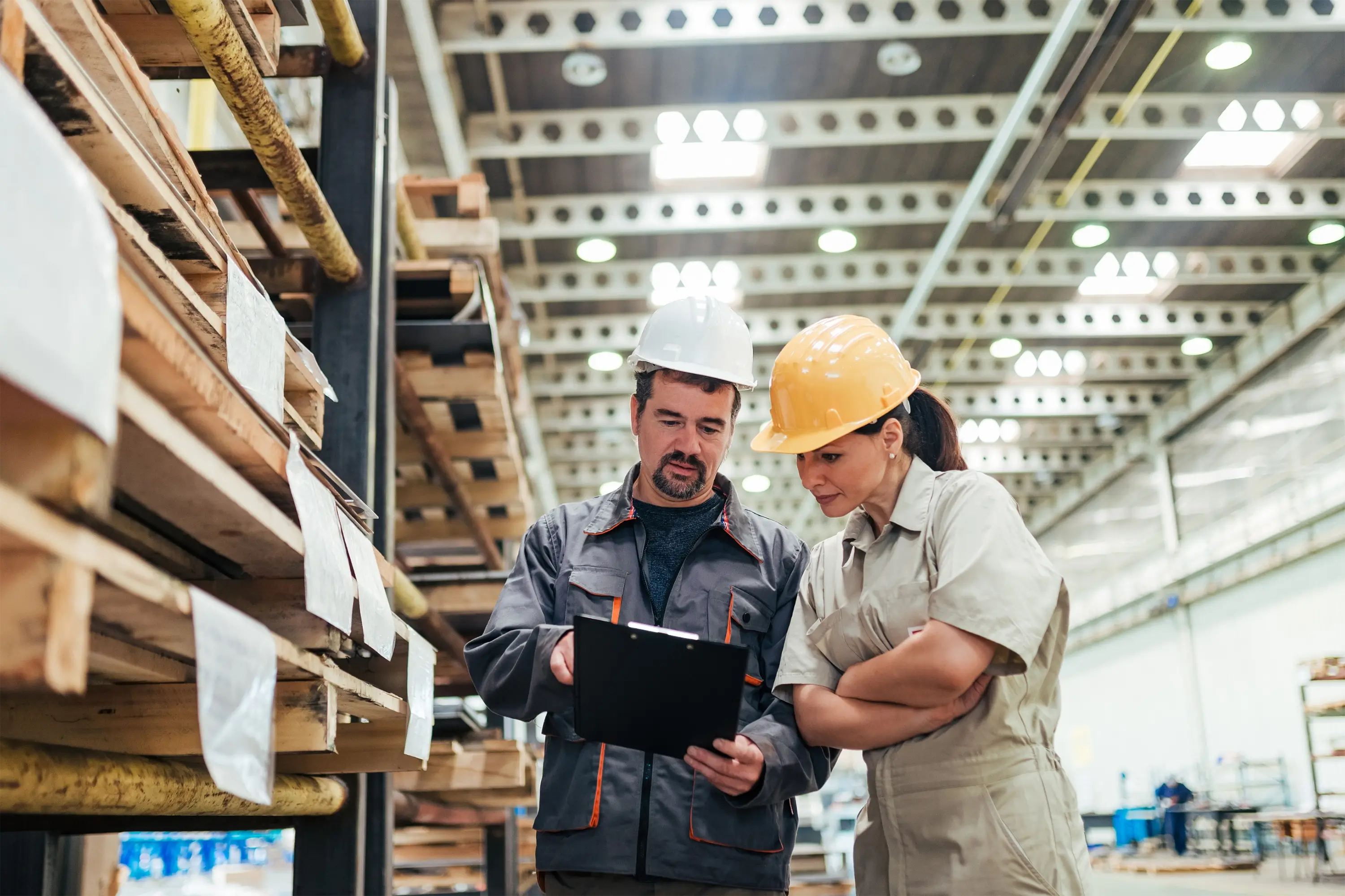 A stock photo of two people wearing hard-hats in a warehouse
